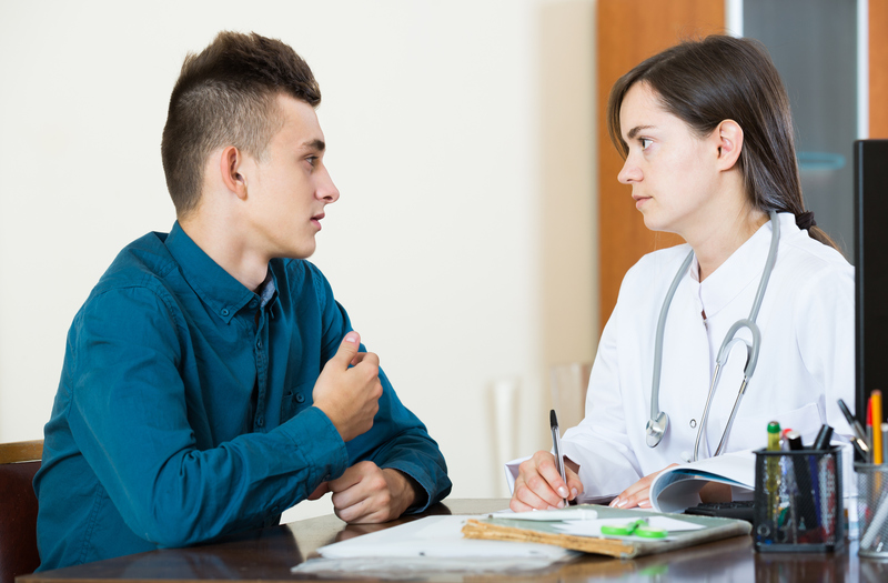 Male teenager talking with a school nurse